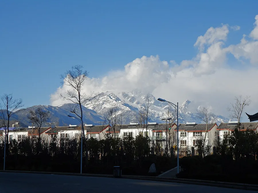 Snow-covered mountains rising behind the buildings of Lijiang, Yunnan